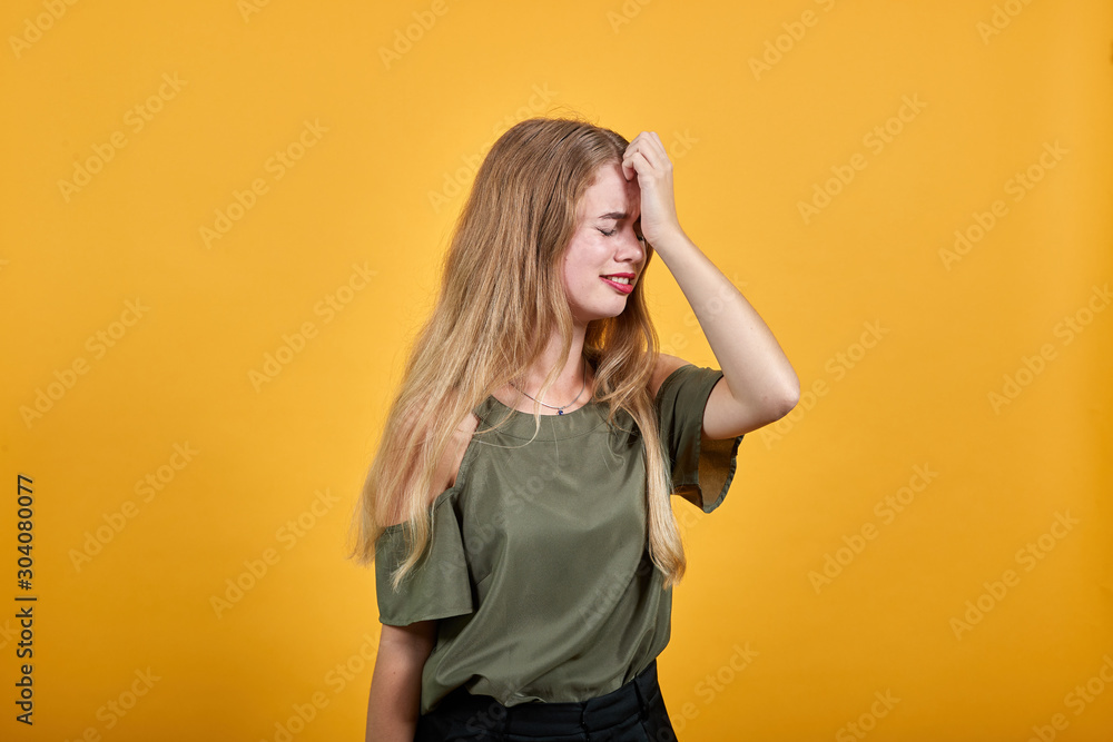 Pretty young caucasian blonde woman wearing nice shirt over white background, looking tired, thinking about issue Pretty young caucasian blonde woman wearing nice shirt over white background, looking tired, thinking about issue