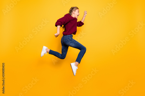 Full length body size view of nice attractive overjoyed cheerful cheery crazy pre-teen girl having fun jumping running isolated over bright vivid shine vibrant yellow color background © deagreez