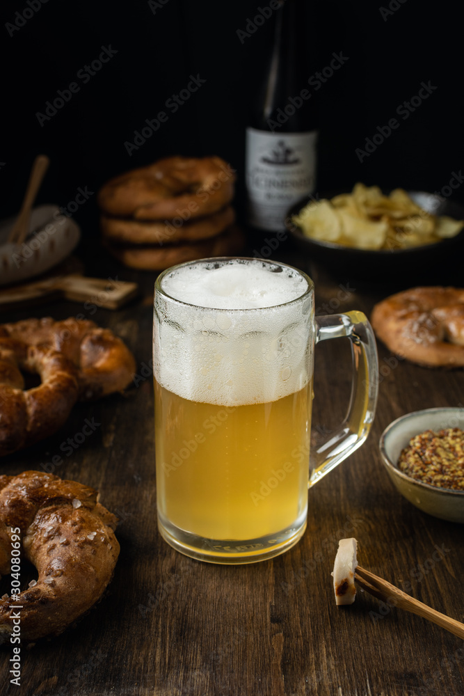 Beer glass with pretzels, bratwurst and snacks on rustic wooden table Beer glass with pretzels, bratwurst and snacks on rustic wooden table
