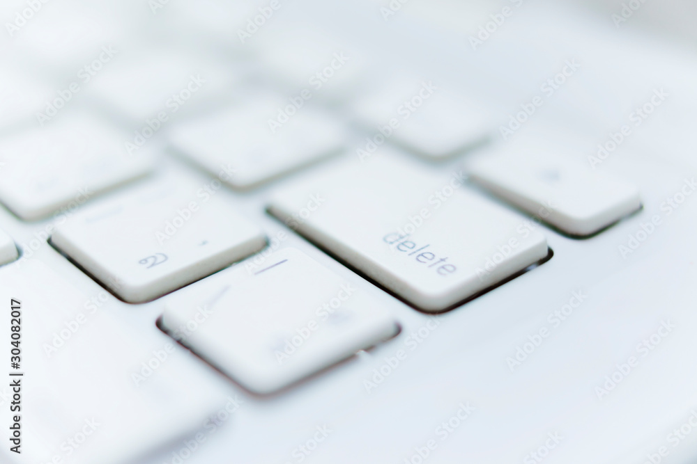 Close up of white keyboard laptop, focus on delete button Close up of white keyboard laptop, focus on delete button