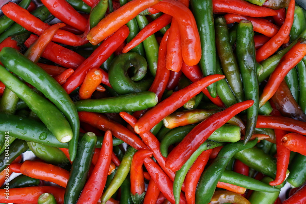 Red and green peppers, emphasizing the selection of pepper, colorful organic food ingredients used as background