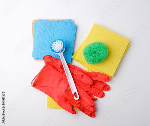 items for home cleaning: red rubber gloves, brush, multi-colored sponges for dusting