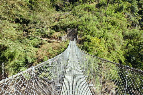 Fototapeta Naklejka Na Ścianę i Meble -  Suspension bridge on hiking trail in Nepal. 