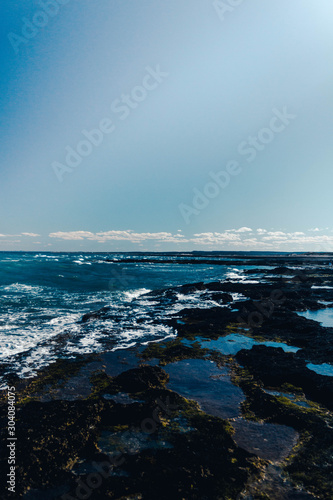 seashore with waves breaking on rocks