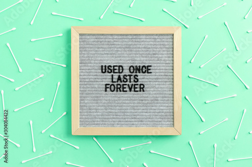 Pattern made of cotton swabs on mint background. Letterboard with quote Used once lasts forever photo