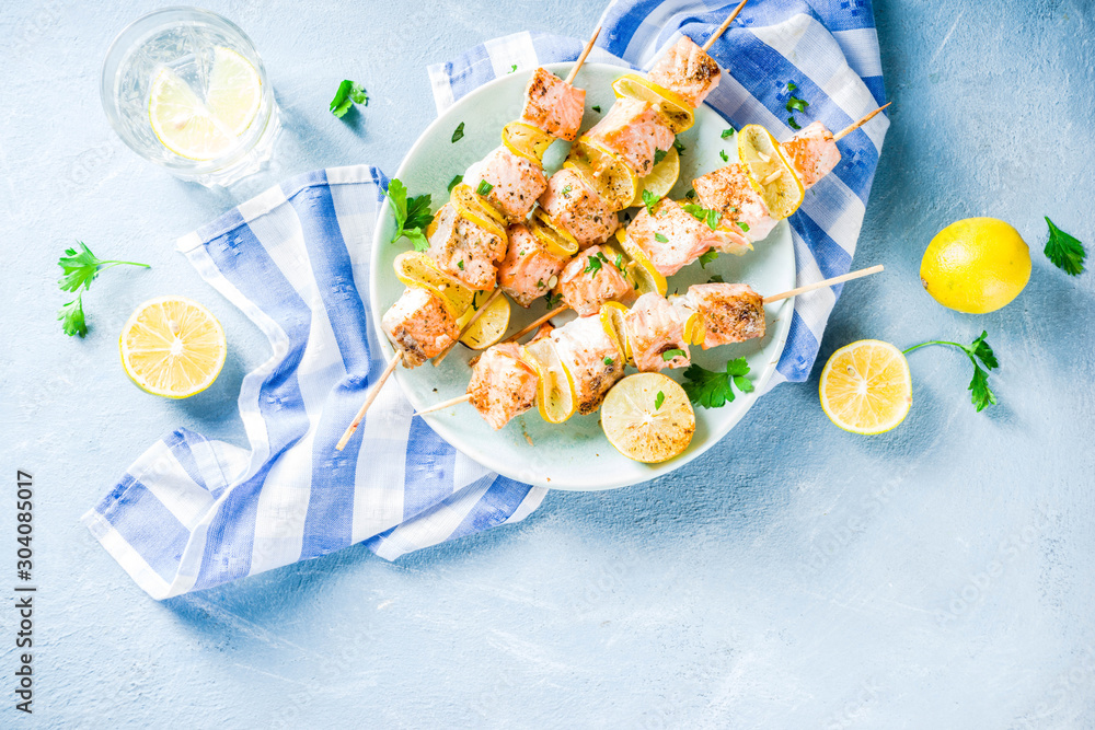 Homemade salmon fish grilled skewers, with lemon and greens Homemade salmon fish grilled skewers, with lemon and greens