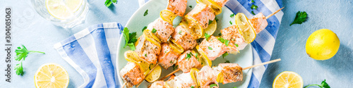 Homemade salmon fish grilled skewers, with lemon and greens
