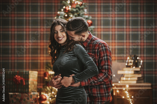 Young couple celebrating Christmas in under the tree