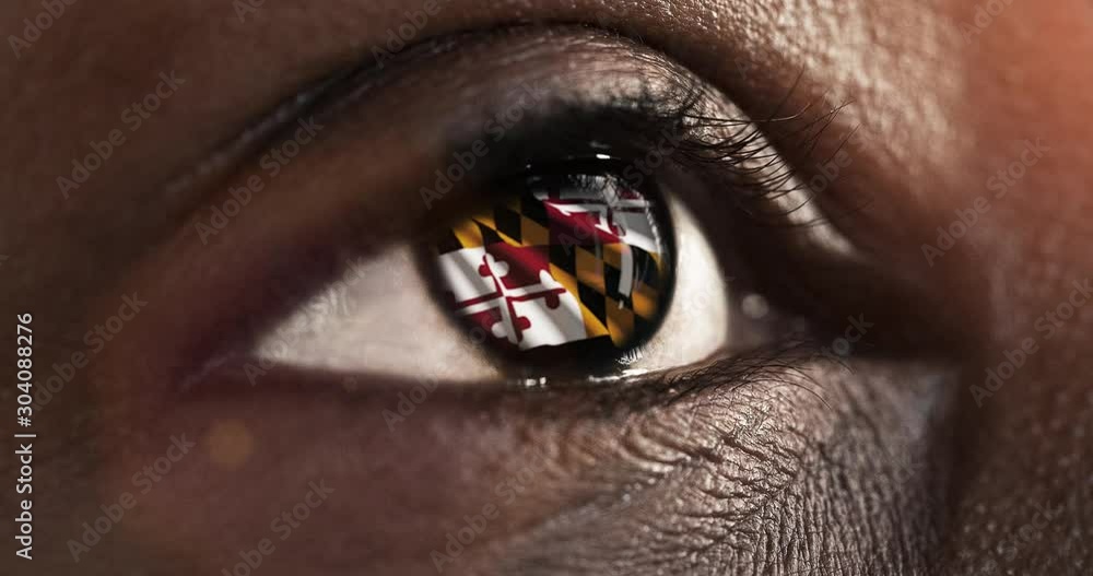 Woman black eye in close up  with the flag of Maryland state in iris, united states of america with wind motion. video concept