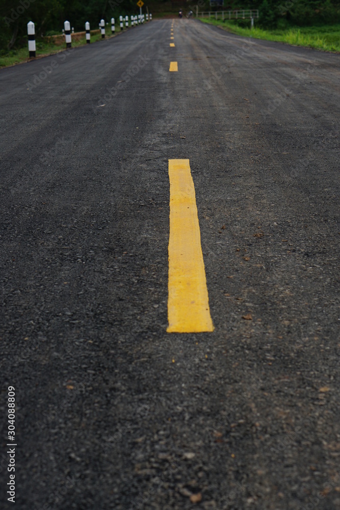 asphalt road with yellow lines