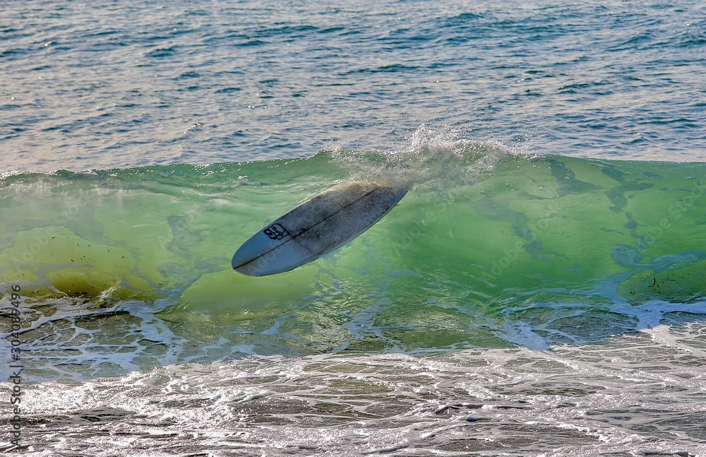 Empty surfboard floating in a wave Stock Photo Adobe Stock