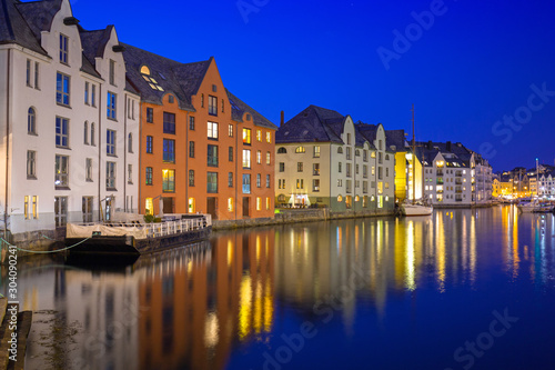 Architecture of Alesund city reflected in the water at night, Norway