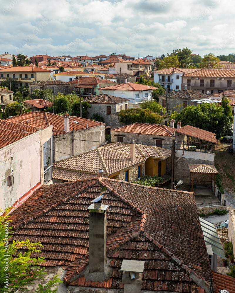 Top view at many red and brown roofs of small houses in small town of Greece. Horizonrtal color photography.