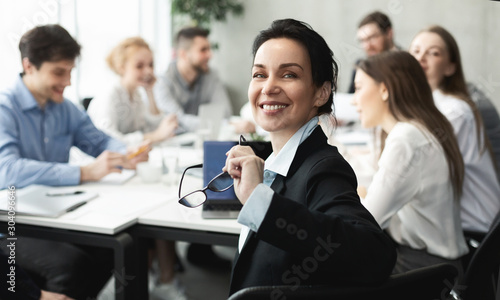Female top manager smiling to camera at meeting