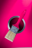 Paint brush on a can with green paint on a purple background brush on a can with pink paint on a pink background