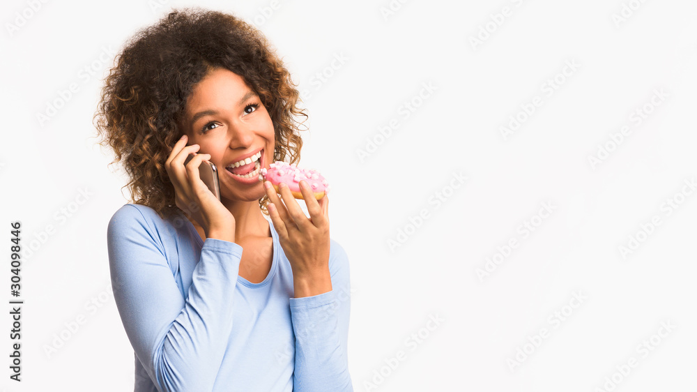 Pregnant woman eating donut and talking on phone Pregnant woman eating donut and talking on phone