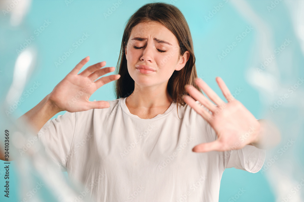 Upset casual girl sadly showing stop gesture to plastic over colorful background isolated Upset casual girl sadly showing stop gesture to plastic over colorful background isolated