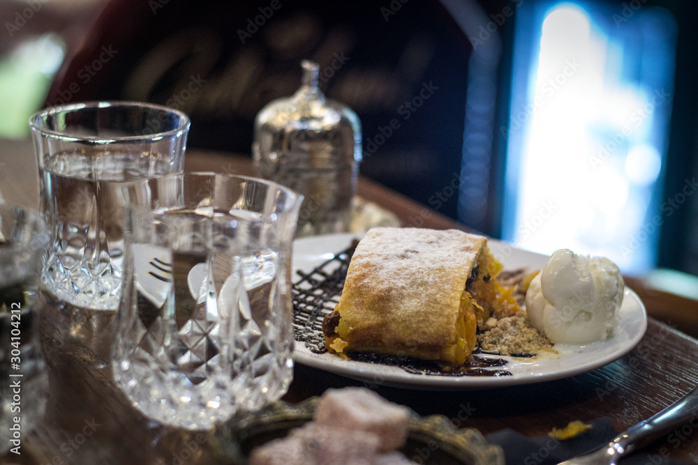 Viennese strudel with ice cream and crystal glasses of water