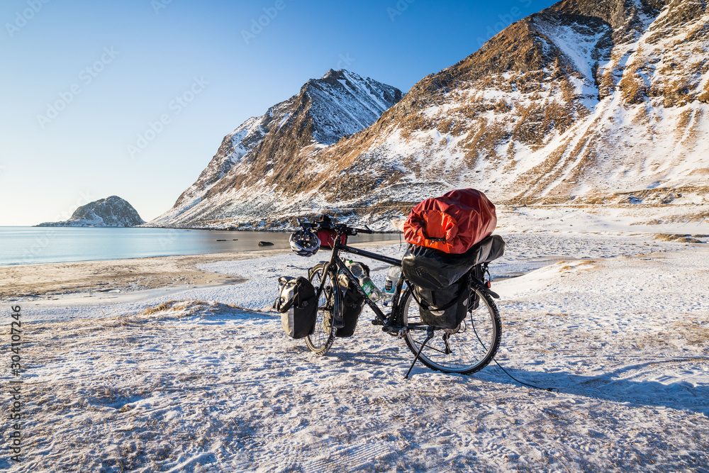 Travel bike in front of the sea on Lofoten islands in winter