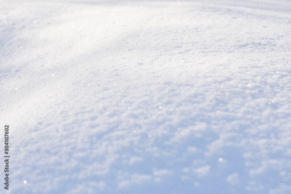 White blue snow texture background with bokeh. Close up of fresh clean snow with blue shadows. Selective focus