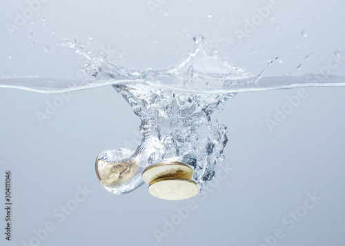 Coins in the water. Splash of coins falling into the water. Coins in the water. Splash of coins falling into the water.