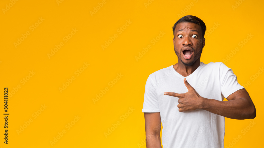Shocked Afro Guy Pointing Finger Aside Standing, Yellow Background, Panorama Shocked Afro Guy Pointing Finger Aside Standing, Yellow Background, Panorama