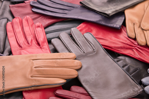 Background of many scattered gloves. Women leather gloves.A collection of colored leather gloves. photo