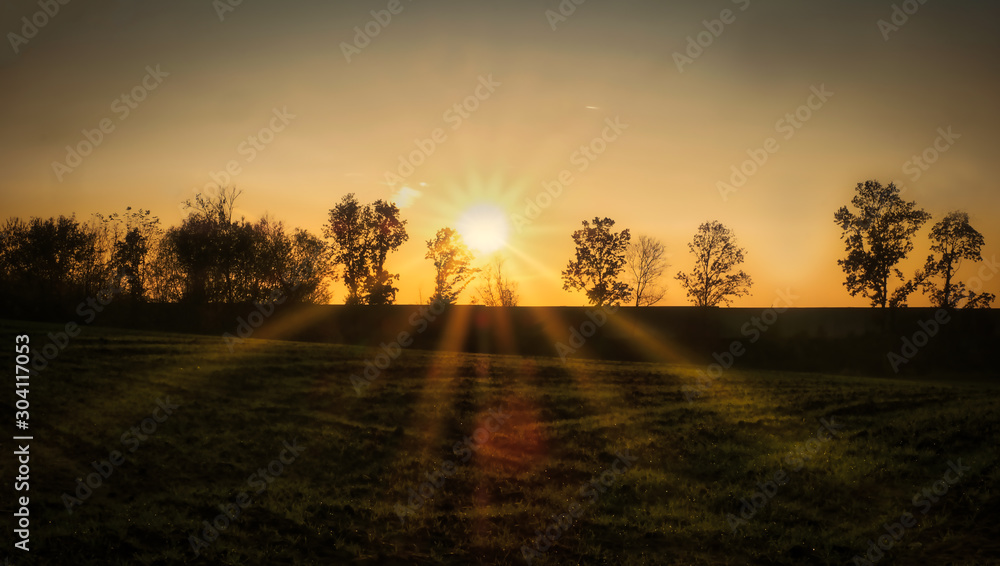 Sonnenuntergang über den Feldern mit Baumgruppe Sonnenuntergang über den Feldern mit Baumgruppe
