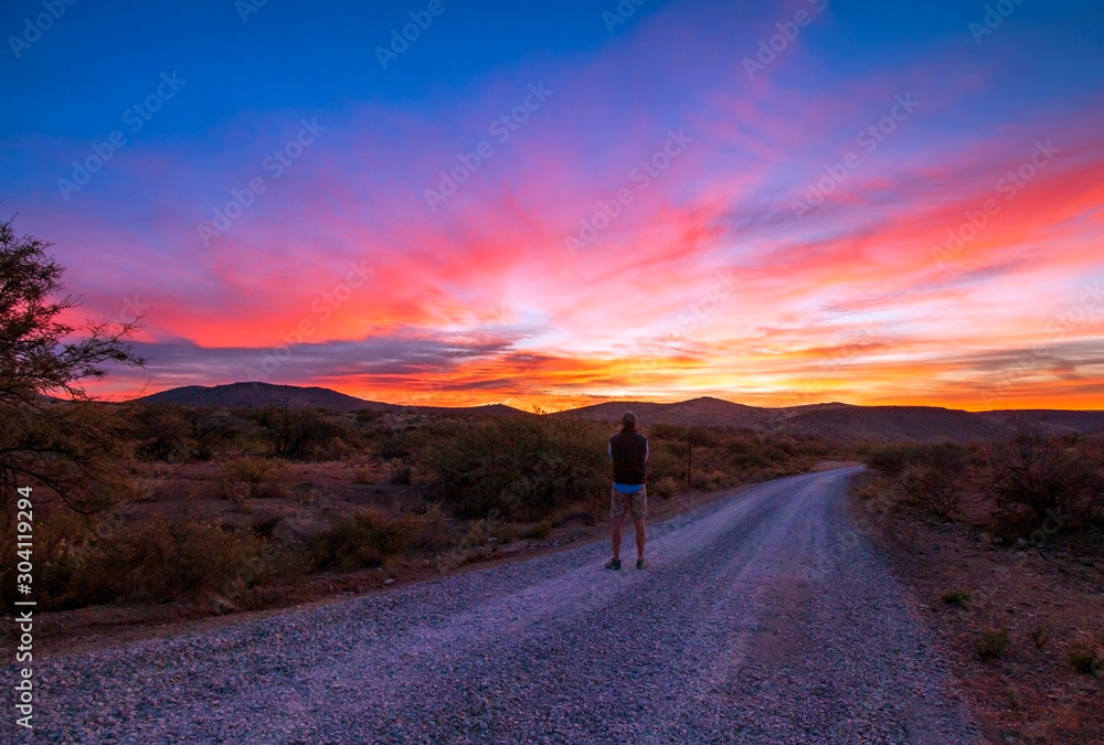 Man Standing On Desert Road At Sunrise In Arizona
