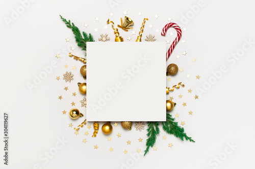 New Year Christmas composition. Blank paper and holiday decorations Christmas balls fir branches confetti Candy Cane on light background. Flat lay top view copy space. Winter New Year 2020 Xmas mockup