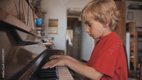 A boy of seven plays the piano at home.