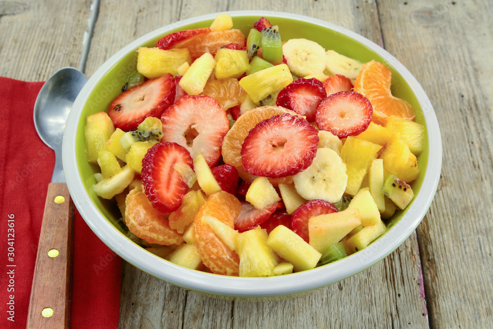 plate of fresh fruit salad on a wooden table plate of fresh fruit salad on a wooden table