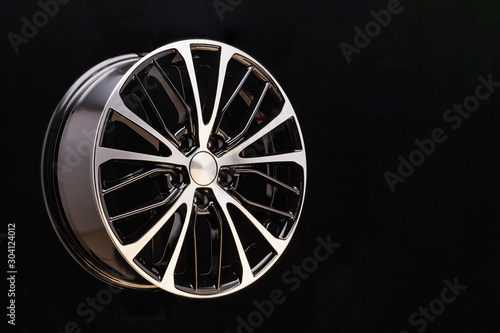 car cast aluminum alloy wheels, black silver with polished front, very beautiful and modern, fashion. Close-up on dark background, elements, spokes.