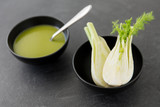 vegetable, food and culinary concept - fennel cream soup in ceramic bowl on slate stone background