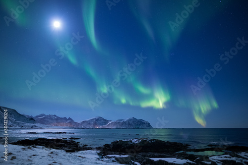 Beautiful northern lights over the snow covered winter landscape of the Lofoten islands