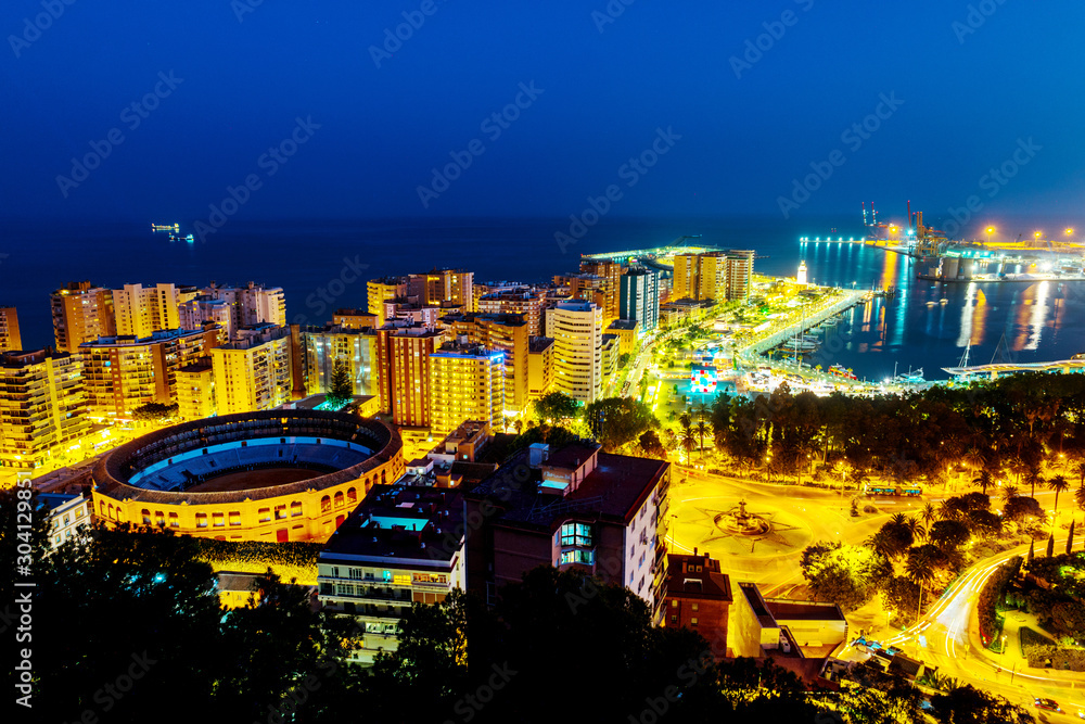 Fototapeta premium Aerial view of the city center at sunset with bullring arena and mediterranean se in Malaga, Spain