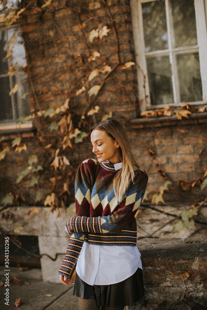 Young woman standing outside at sunny autumn day