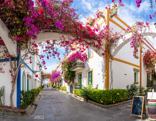 Street with blooming trees in Puerto de Mogan, Gran Canaria, Spain. Favorite vacation place for tourists and locals on island. photo