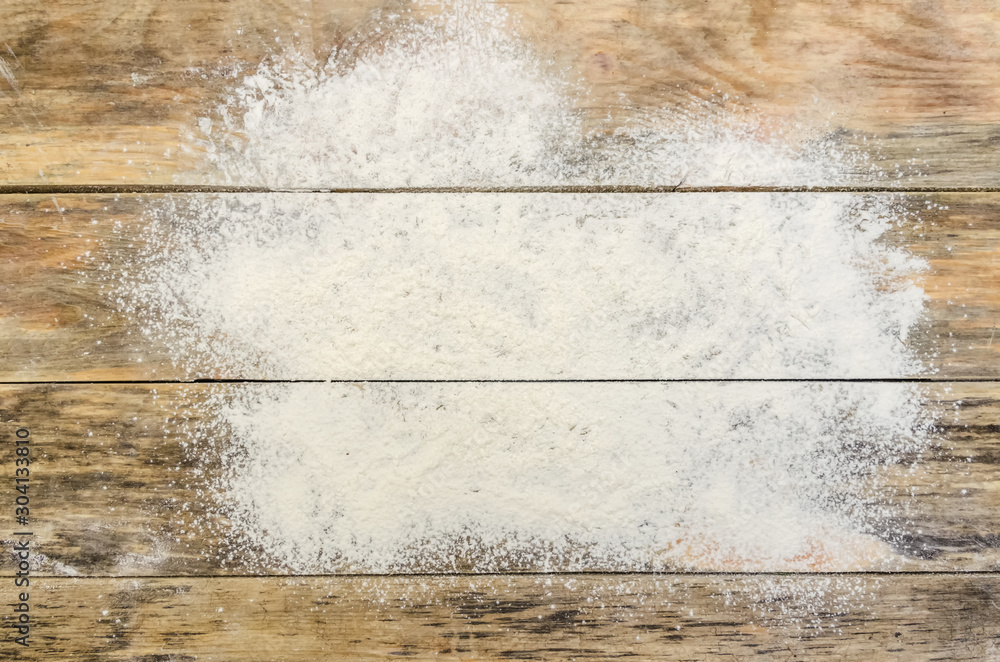 White flour on a wooden background, top view. Background with copy space - obrazy, fototapety, plakaty 