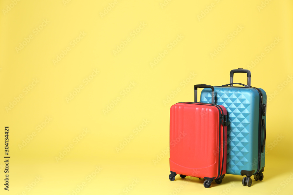 Stylish suitcases on yellow background. Space for text Stylish suitcases on yellow background. Space for text