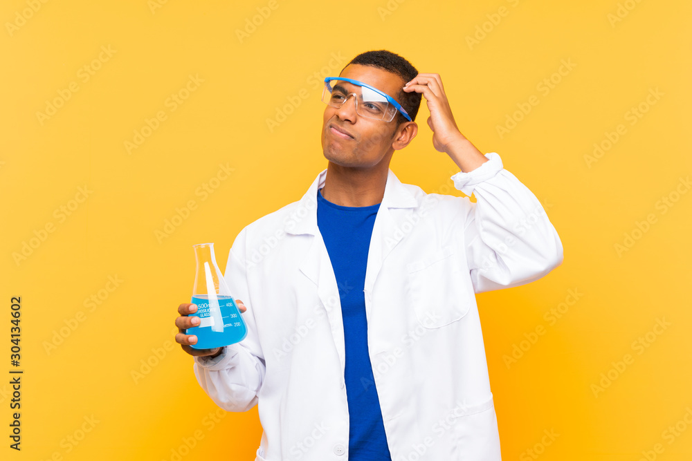 Scientific man holding a laboratory flask over isolated background having doubts and with confuse face expression Scientific man holding a laboratory flask over isolated background having doubts and with confuse face expression