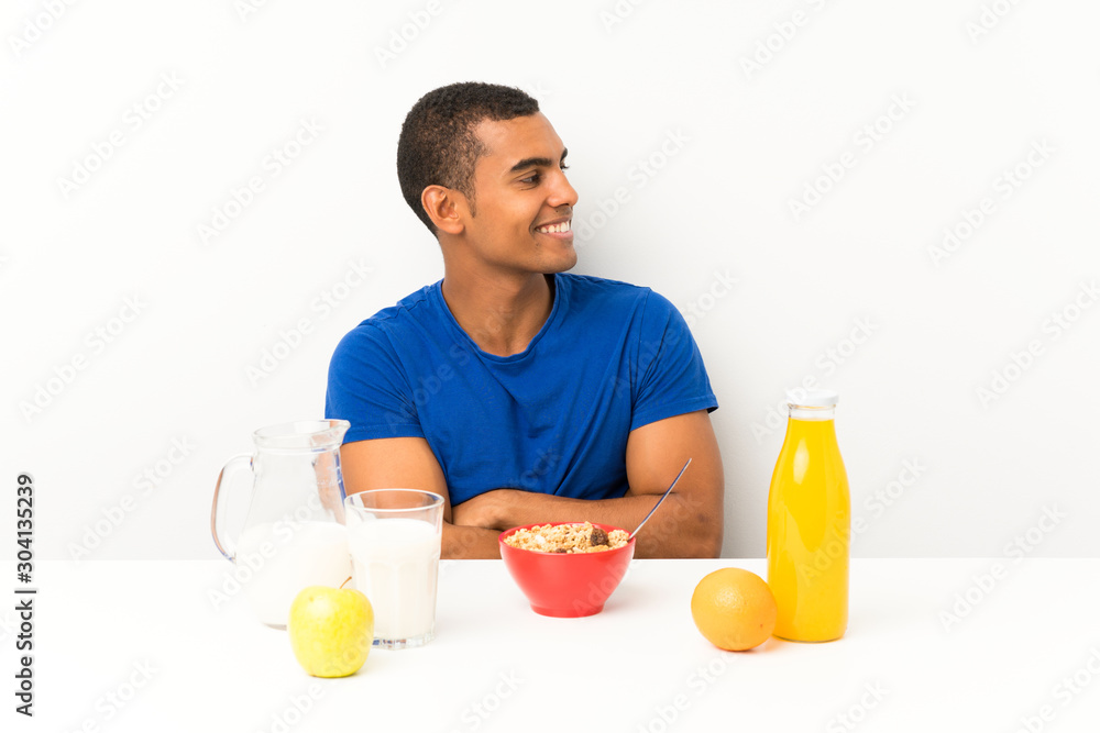 Young man having breakfast in a table looking to the side Young man having breakfast in a table looking to the side