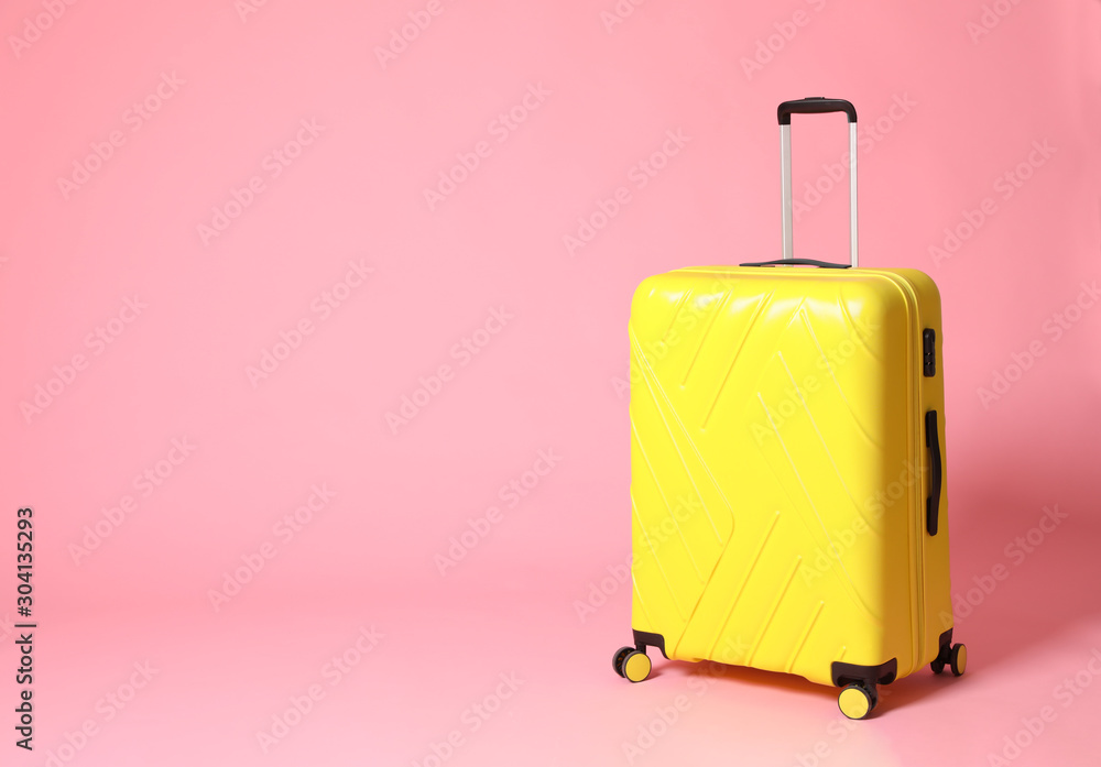Stylish yellow suitcase on pink background. Space for text Stylish yellow suitcase on pink background. Space for text