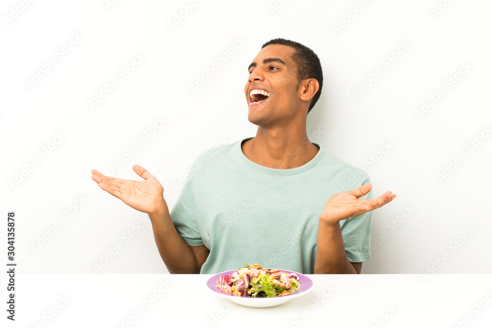 Young handsome man with salad in a table with surprise facial expression Young handsome man with salad in a table with surprise facial expression