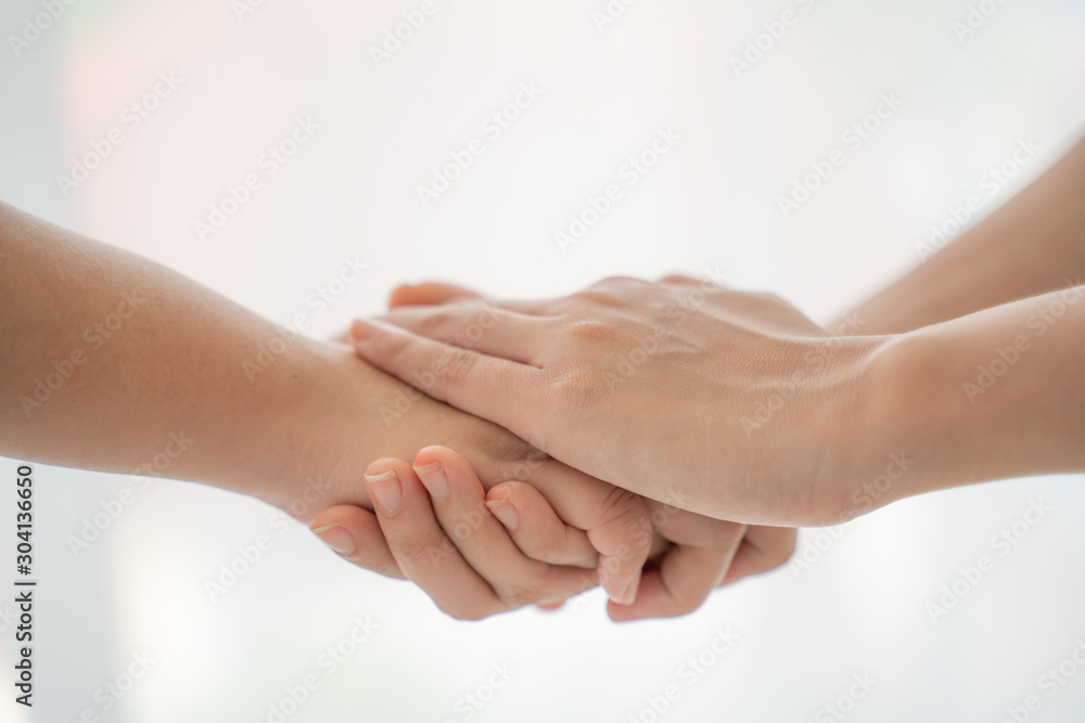 World peace concept.Two people holding hand together over blurred white background with copy space,Business man and woman shaking hands,helping hand. World peace concept.Two people holding hand together over blurred white background with copy space,Business man and woman shaking hands,helping hand.