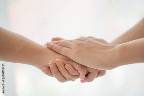 World peace concept.Two people holding hand together over blurred white background with copy space,Business man and woman shaking hands,helping hand.