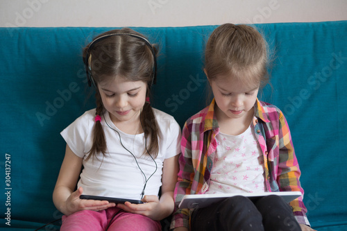 Little girsl watching cartoons on a tablet and playing games photo