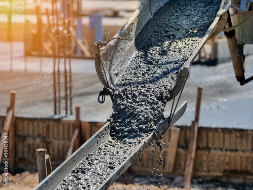 Construction worker Concrete pouring during commercial concreting floors of building in construction site