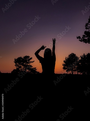 silhouette of young woman doing yoga at sunset