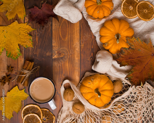 Autumn still life with pumpkins and leaves on wooden background.